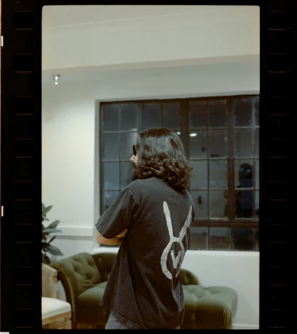 The artist seen from behind wearing the VAURA symbol in the studio